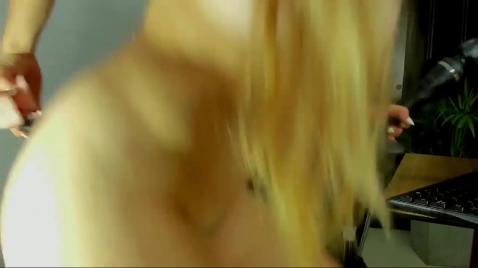 Uma loira se masturba com um vibrador enquanto está sentada em uma cadeira.