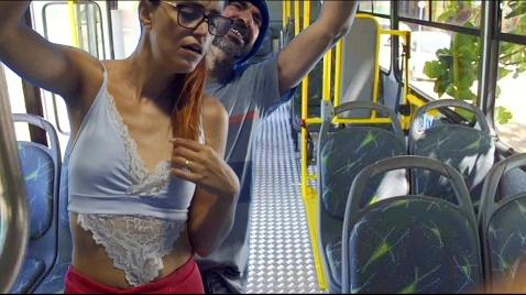 Um homem em pé num ônibus fode uma jovem morena na bunda.