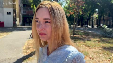 Uma loira é filmada andando pela cidade.