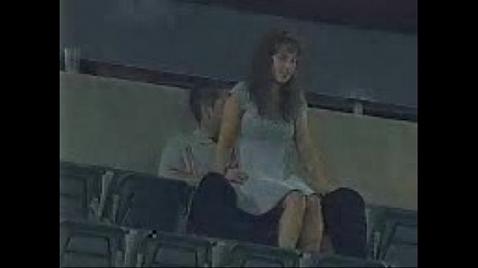 Um casal está fazendo sexo nas arquibancadas do estádio.